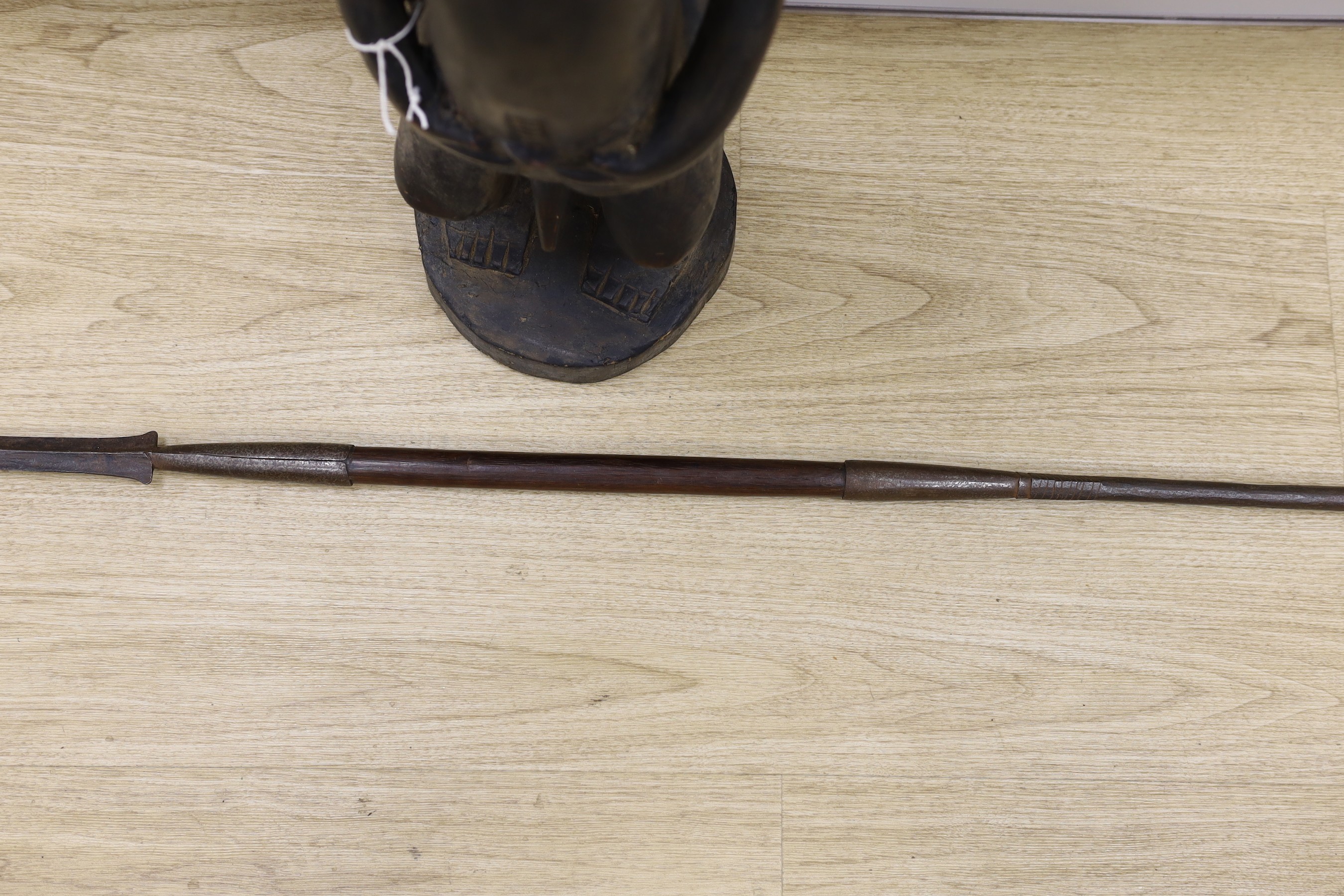 An African Boule crouched tribal figure, together with a spear, 156cm long